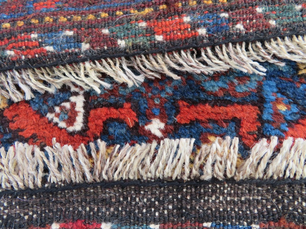 An antique Khamseh hand-knotted wool tribal rug featuring three central diamond medallions surrounded by small bird and geometric motifs in deep blue, terracotta red, and cream. View XIX