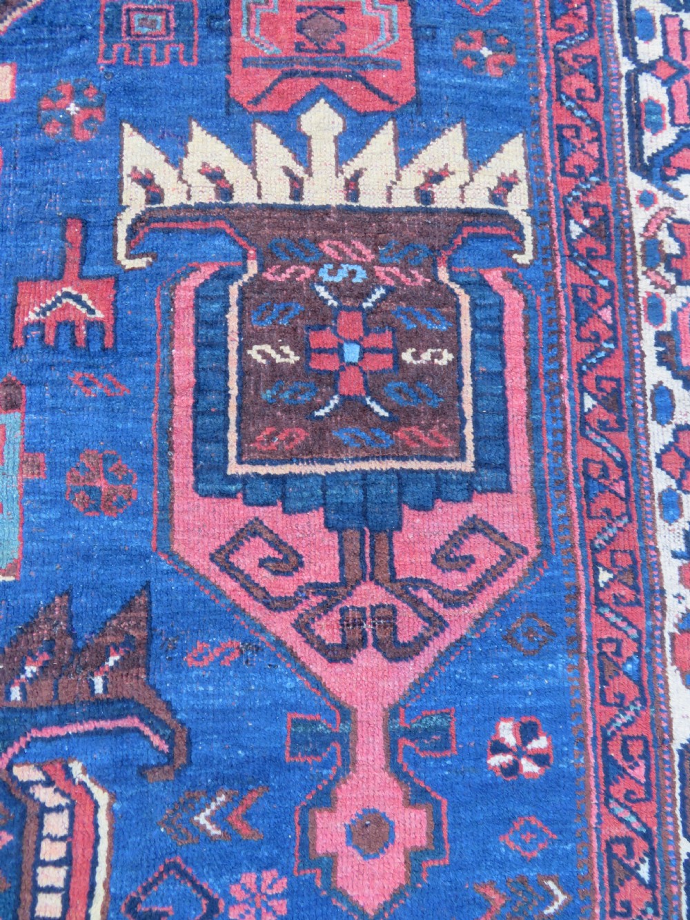 An antique hand-knotted Afshar wool rug featuring a vibrant indigo blue central field with stylized geometric medallions surrounded by detailed terracotta red and ivory borders. View II