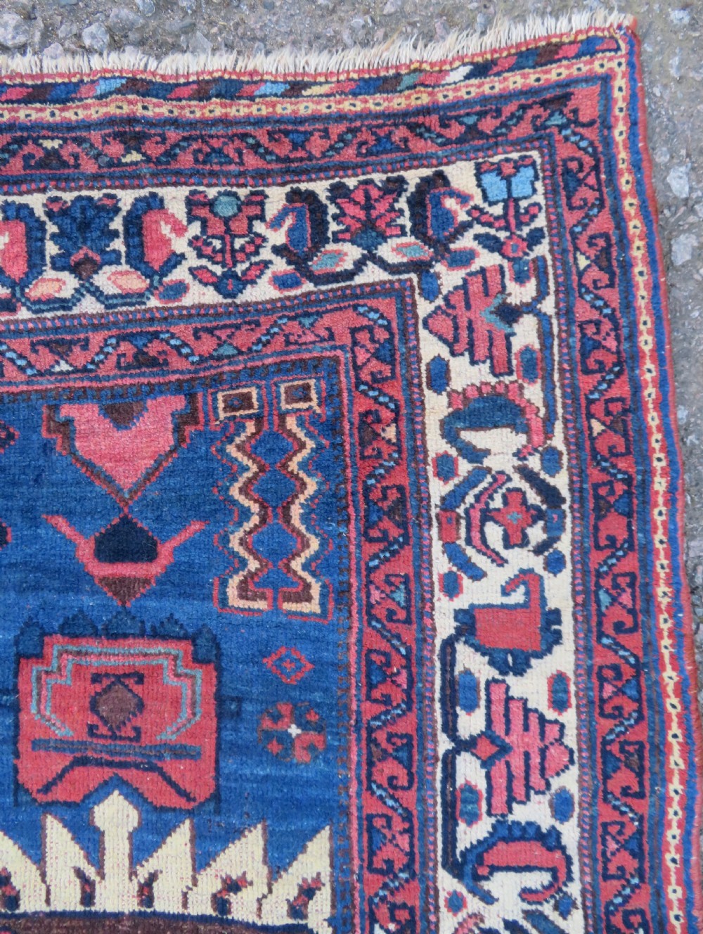 An antique hand-knotted Afshar wool rug featuring a vibrant indigo blue central field with stylized geometric medallions surrounded by detailed terracotta red and ivory borders. View VII