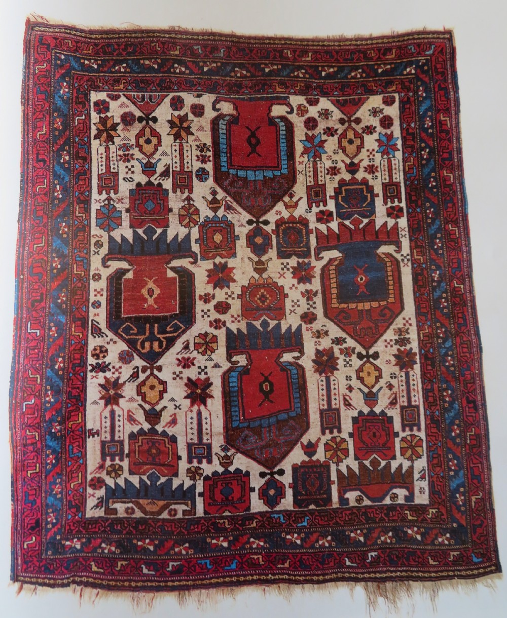 An antique hand-knotted Afshar wool rug featuring a vibrant indigo blue central field with stylized geometric medallions surrounded by detailed terracotta red and ivory borders. View XVIII