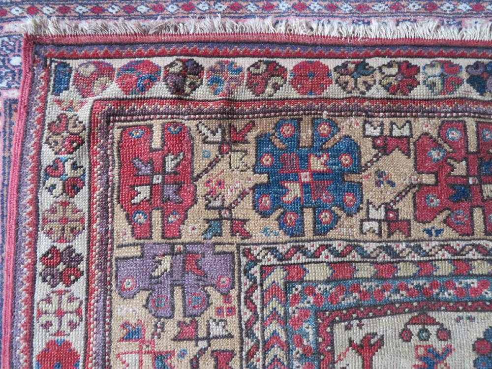 An antique hand-knotted Turkish Milas wool prayer rug featuring a central pointed arch motif in terracotta surrounded by broad geometric floral borders in cream, red, and blue shades. View VI