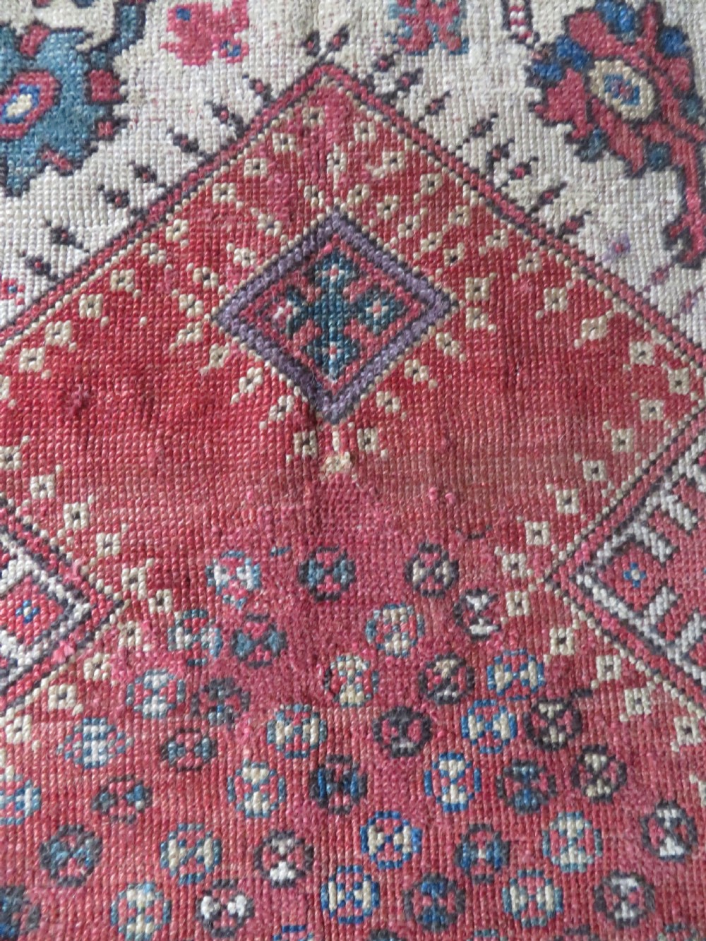 An antique hand-knotted Turkish Milas wool prayer rug featuring a central pointed arch motif in terracotta surrounded by broad geometric floral borders in cream, red, and blue shades. View IX