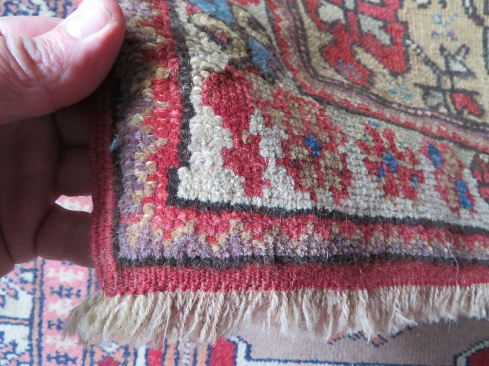 An antique hand-knotted Turkish Milas wool prayer rug featuring a central pointed arch motif in terracotta surrounded by broad geometric floral borders in cream, red, and blue shades. View XI