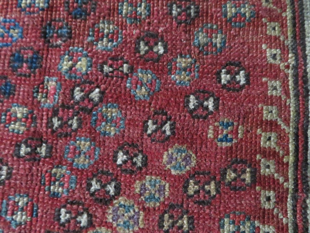 An antique hand-knotted Turkish Milas wool prayer rug featuring a central pointed arch motif in terracotta surrounded by broad geometric floral borders in cream, red, and blue shades. View XIII