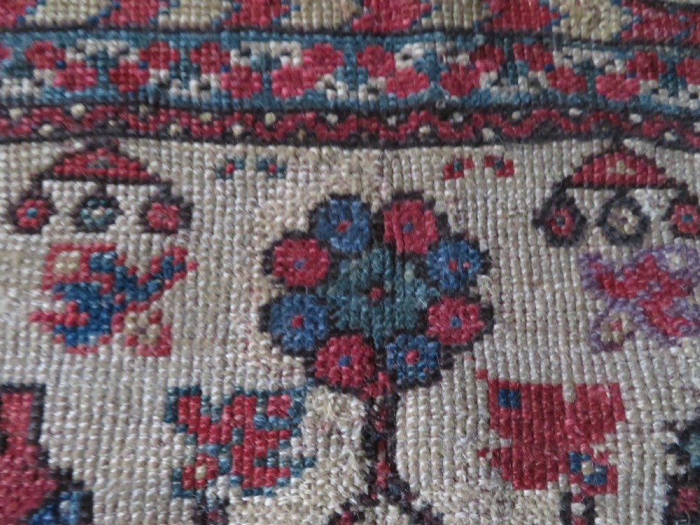 An antique hand-knotted Turkish Milas wool prayer rug featuring a central pointed arch motif in terracotta surrounded by broad geometric floral borders in cream, red, and blue shades. View XIV