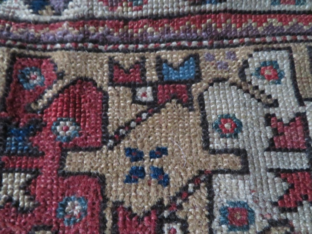 An antique hand-knotted Turkish Milas wool prayer rug featuring a central pointed arch motif in terracotta surrounded by broad geometric floral borders in cream, red, and blue shades. View XV