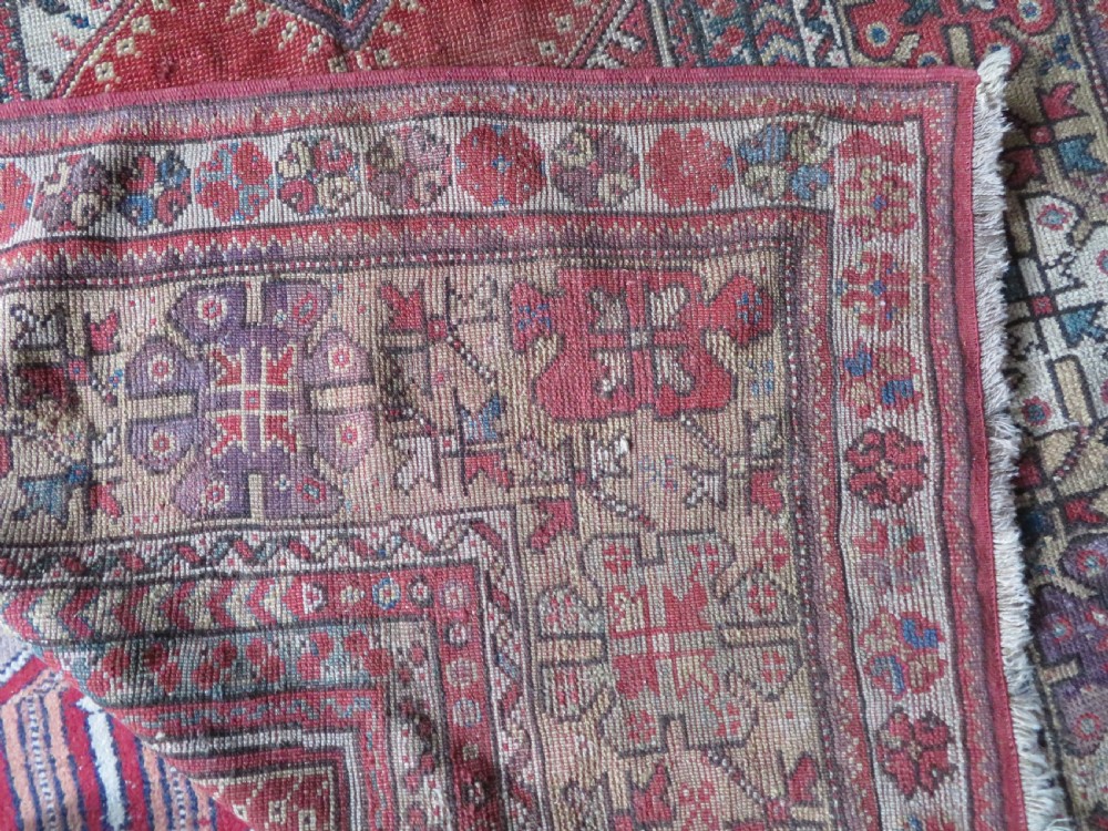 An antique hand-knotted Turkish Milas wool prayer rug featuring a central pointed arch motif in terracotta surrounded by broad geometric floral borders in cream, red, and blue shades. View XVI