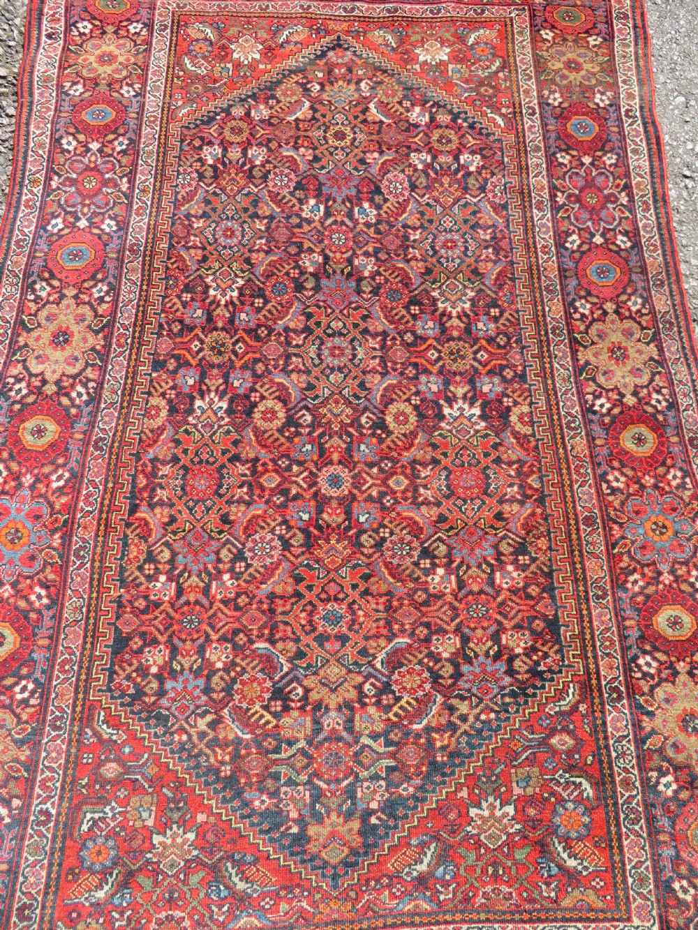 A hand-knotted antique Malayer rug featuring a central navy diamond medallion surrounded by elaborate geometric red and floral pattern borders. View II