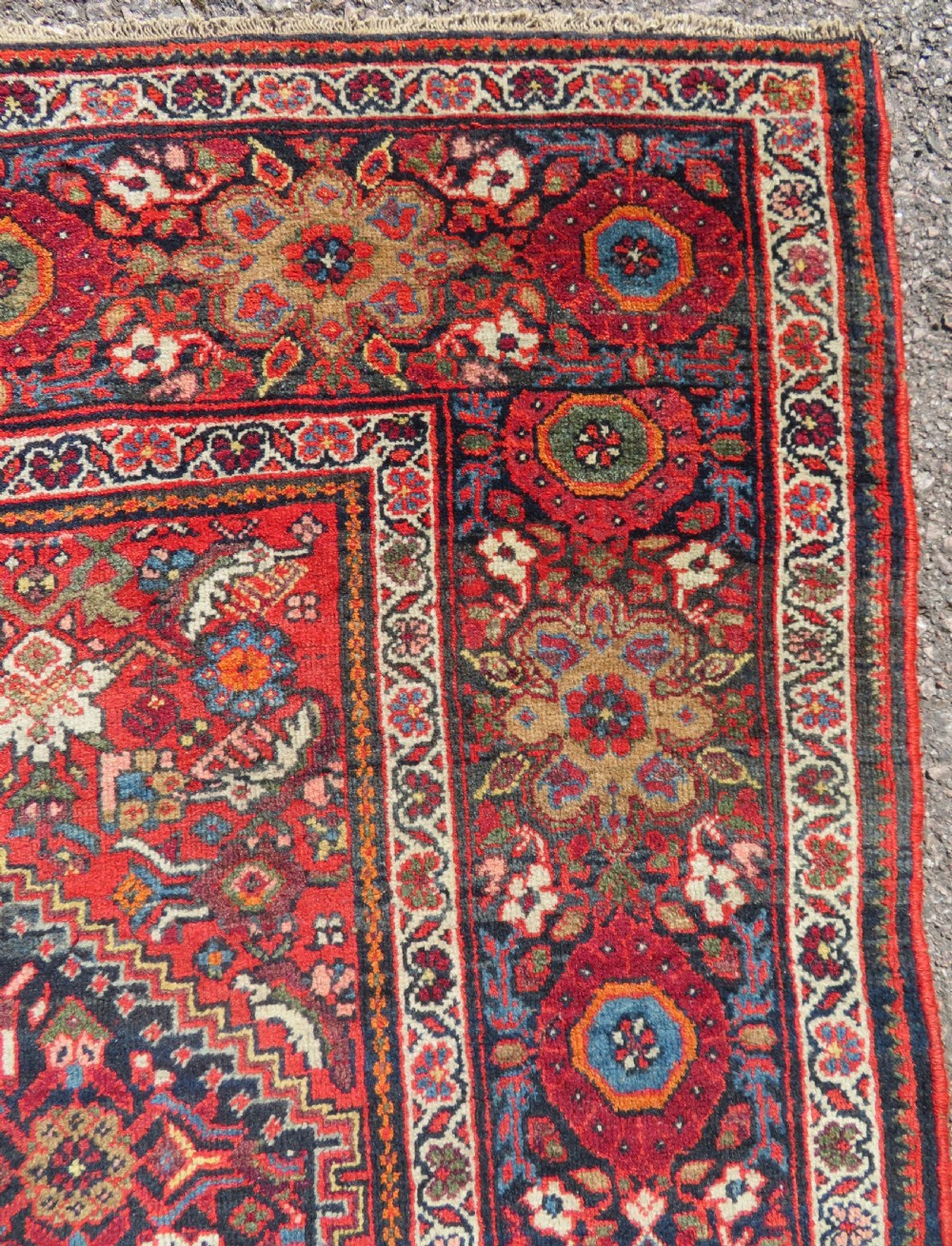A hand-knotted antique Malayer rug featuring a central navy diamond medallion surrounded by elaborate geometric red and floral pattern borders. View VII