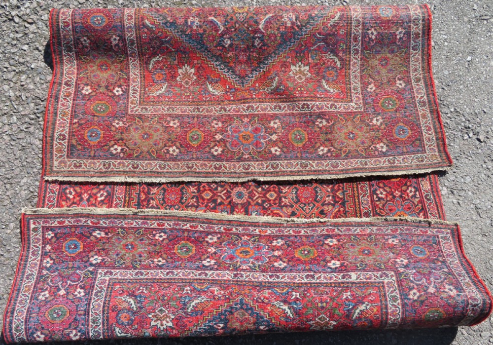 A hand-knotted antique Malayer rug featuring a central navy diamond medallion surrounded by elaborate geometric red and floral pattern borders. View XII
