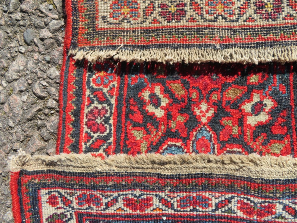 A hand-knotted antique Malayer rug featuring a central navy diamond medallion surrounded by elaborate geometric red and floral pattern borders. View XIII