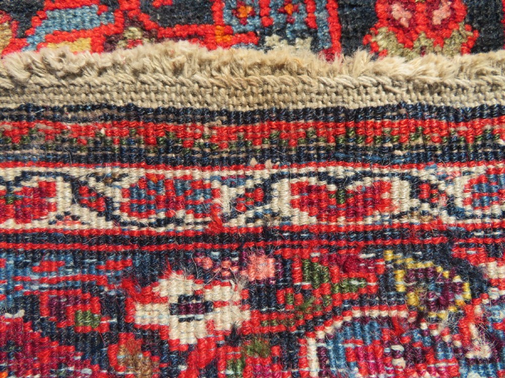 A hand-knotted antique Malayer rug featuring a central navy diamond medallion surrounded by elaborate geometric red and floral pattern borders. View XIV