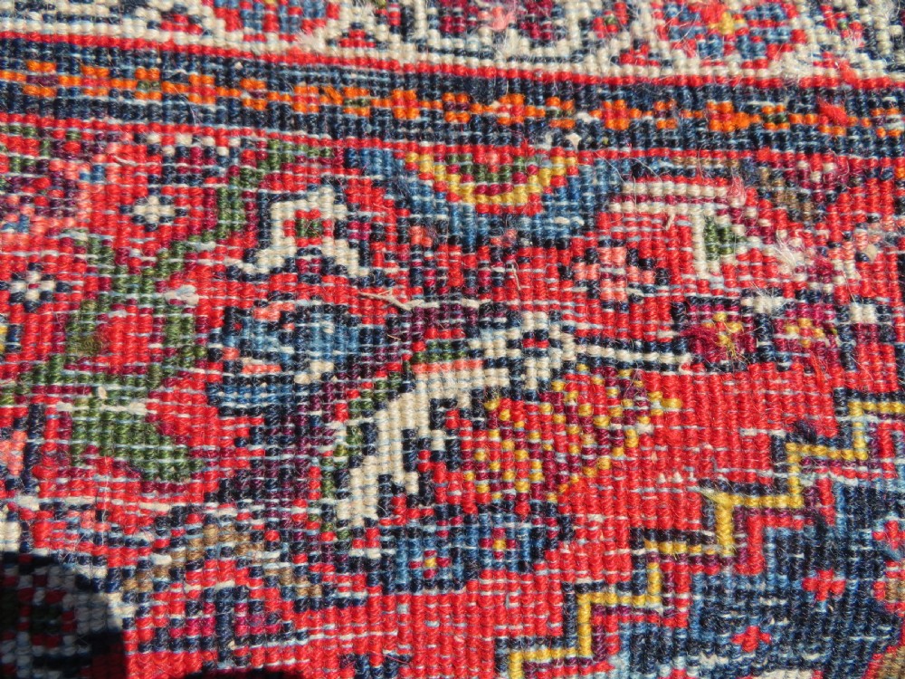 A hand-knotted antique Malayer rug featuring a central navy diamond medallion surrounded by elaborate geometric red and floral pattern borders. View XV