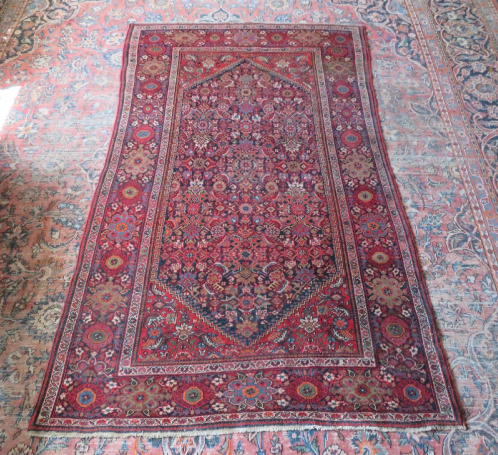 A hand-knotted antique Malayer rug featuring a central navy diamond medallion surrounded by elaborate geometric red and floral pattern borders. View XVI
