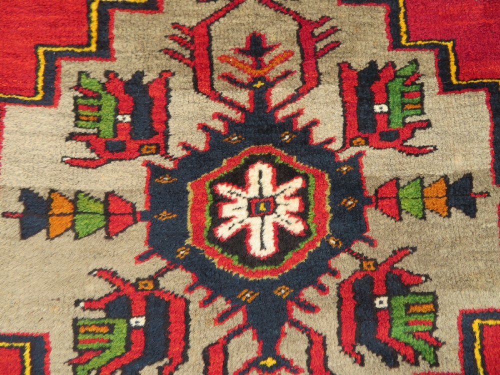 A hand-knotted Turkish Yahyali rug featuring a stepped central medallion in red, navy blue, and beige, framed by a broad ochre geometric border. View III