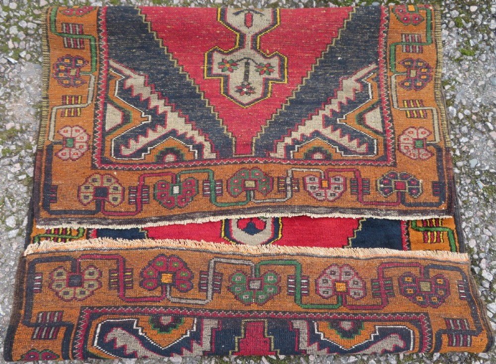 A hand-knotted Turkish Yahyali rug featuring a stepped central medallion in red, navy blue, and beige, framed by a broad ochre geometric border. View X