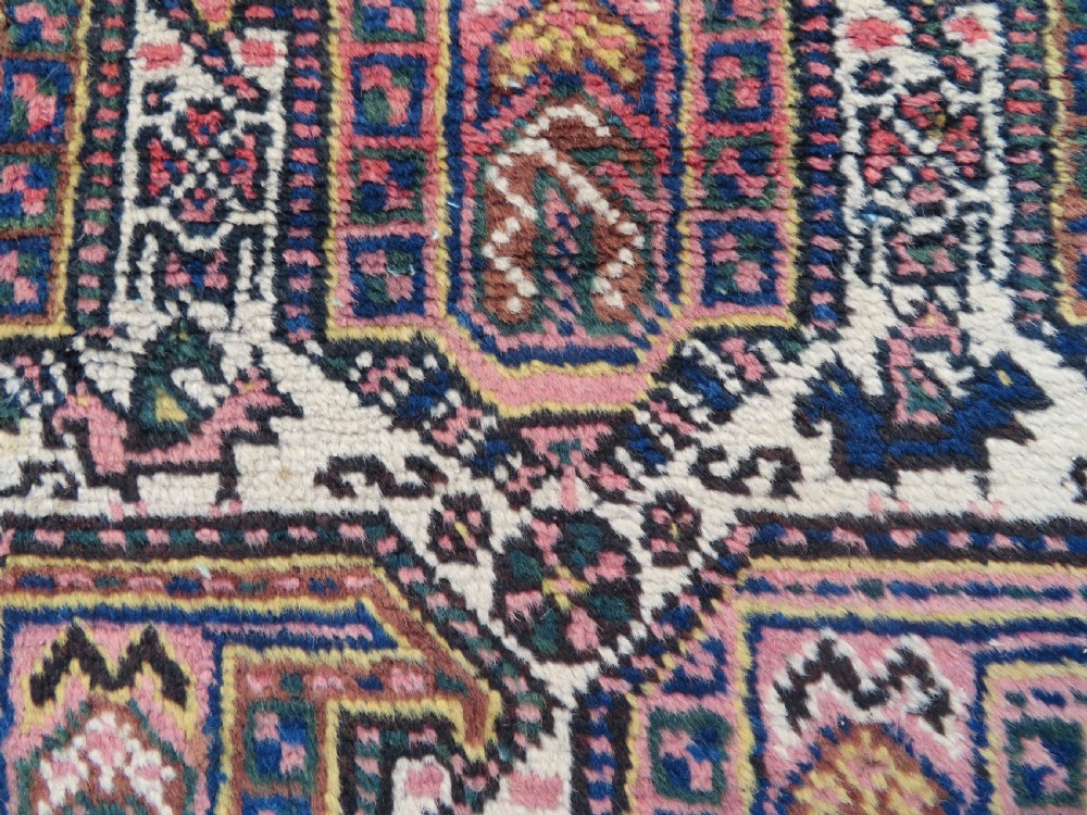 An antique hand-knotted Afshar wool rug featuring a repeating geometric motif on an ivory ground with dark blue and terracotta decorative borders. View IV