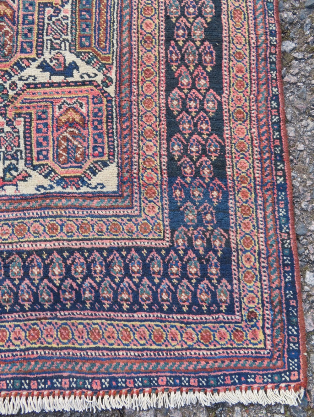 An antique hand-knotted Afshar wool rug featuring a repeating geometric motif on an ivory ground with dark blue and terracotta decorative borders. View VII
