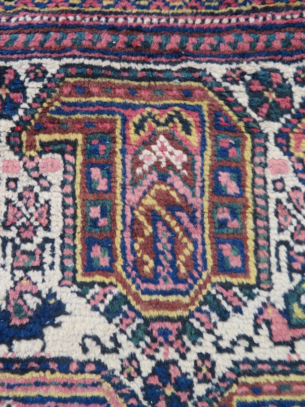 An antique hand-knotted Afshar wool rug featuring a repeating geometric motif on an ivory ground with dark blue and terracotta decorative borders. View XI