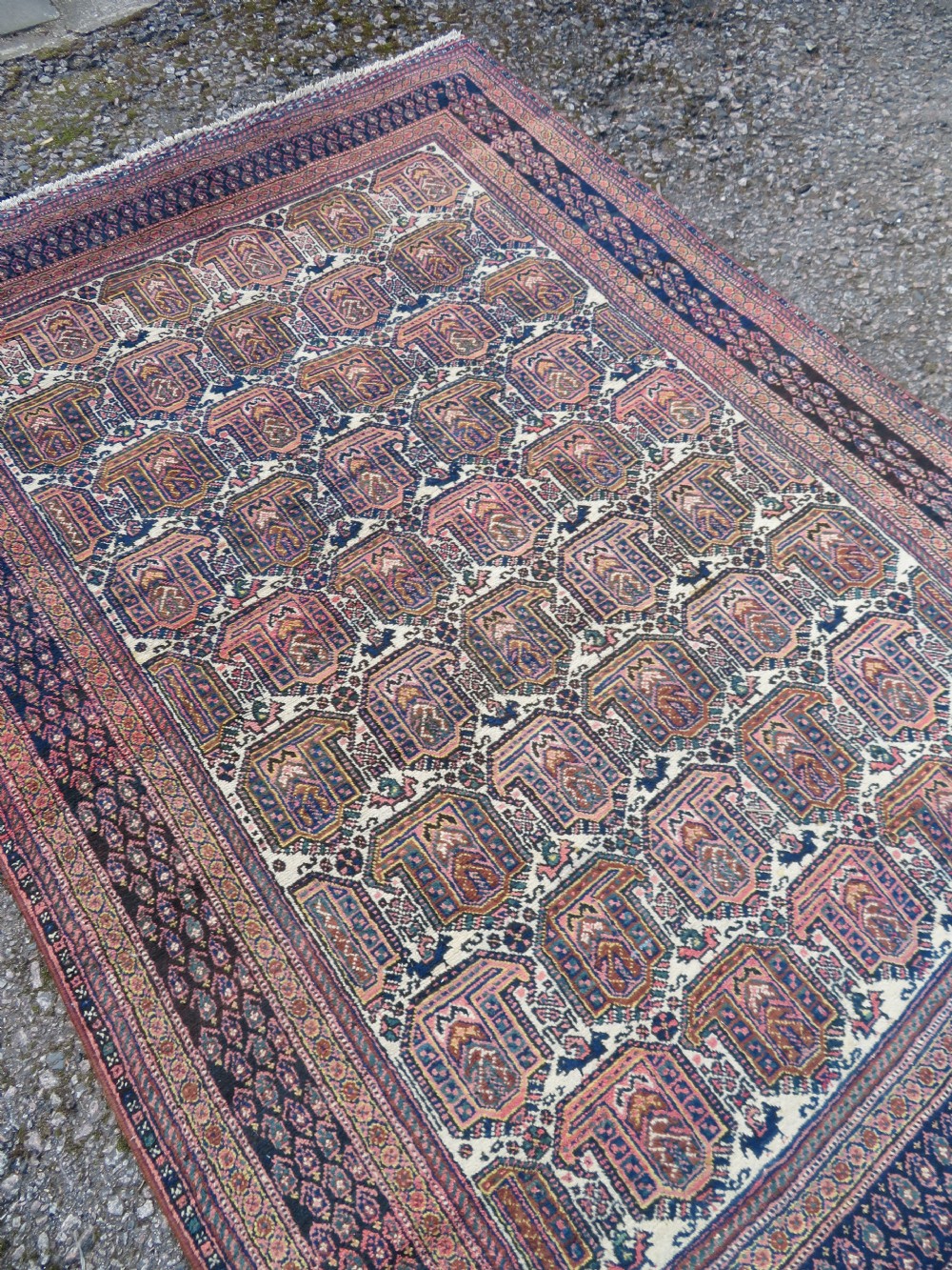 An antique hand-knotted Afshar wool rug featuring a repeating geometric motif on an ivory ground with dark blue and terracotta decorative borders. View XII