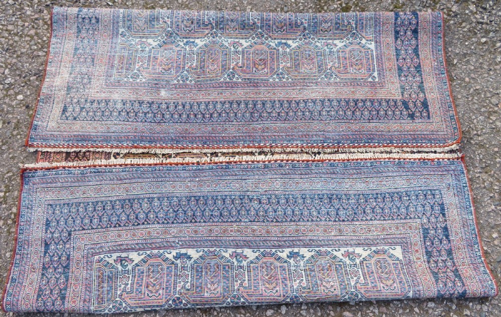 An antique hand-knotted Afshar wool rug featuring a repeating geometric motif on an ivory ground with dark blue and terracotta decorative borders. View XIV