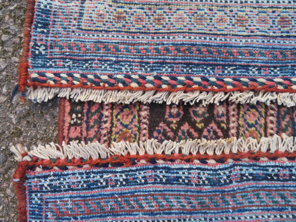 An antique hand-knotted Afshar wool rug featuring a repeating geometric motif on an ivory ground with dark blue and terracotta decorative borders. View XV