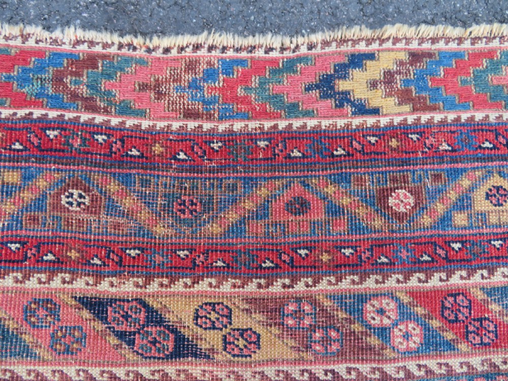 An antique Khamseh hand-knotted wool rug featuring five central diamond medallions on a dark navy and red field decorated with tribal bird motifs. View XII