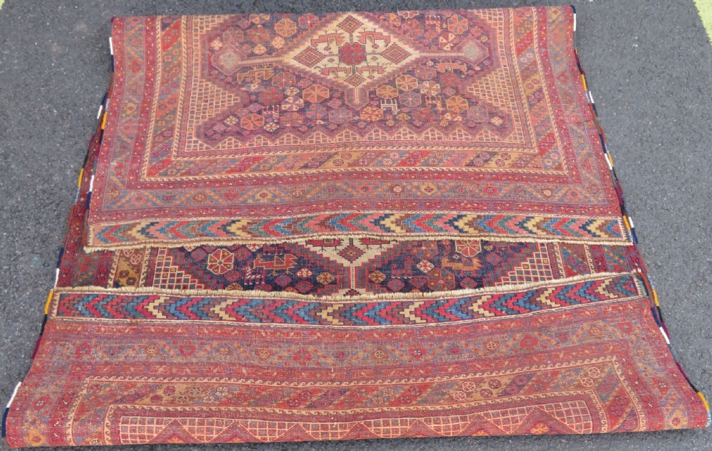 An antique Khamseh hand-knotted wool rug featuring five central diamond medallions on a dark navy and red field decorated with tribal bird motifs. View XX