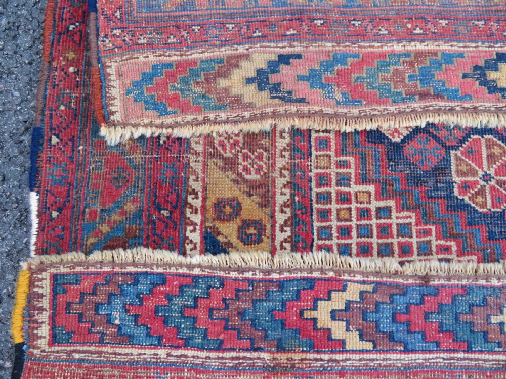 An antique Khamseh hand-knotted wool rug featuring five central diamond medallions on a dark navy and red field decorated with tribal bird motifs. View XXI