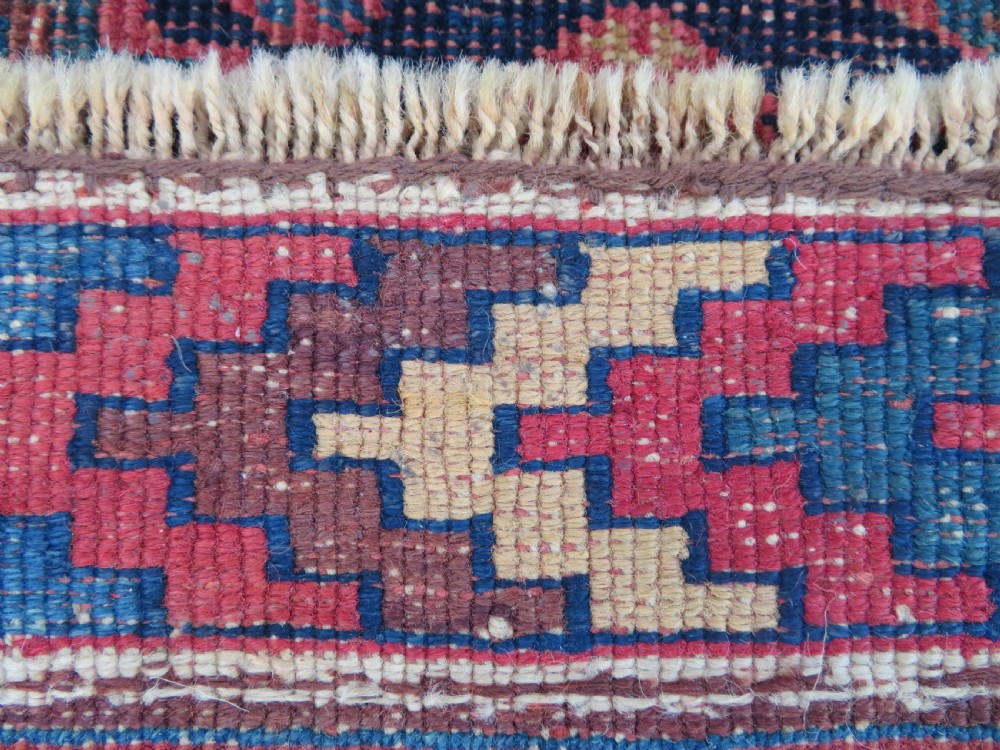 An antique Khamseh hand-knotted wool rug featuring five central diamond medallions on a dark navy and red field decorated with tribal bird motifs. View XXIII