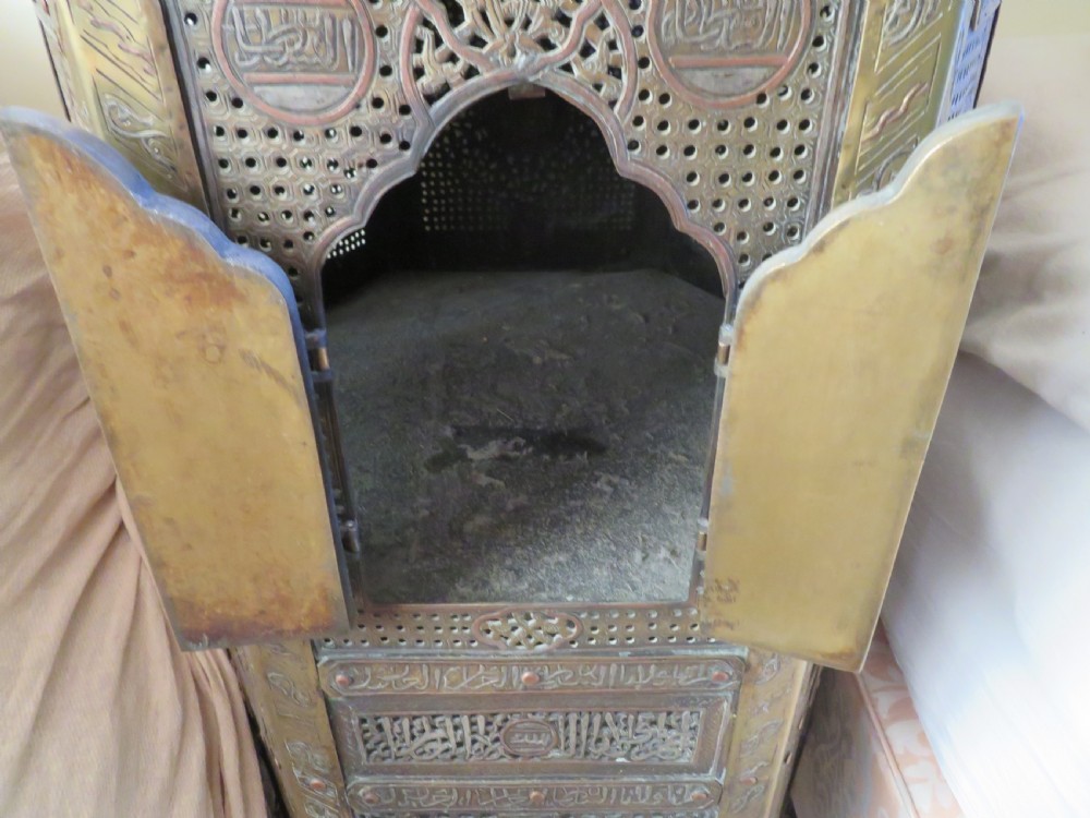 A hexagonal antique brass occasional table with pierced openwork panels, Arabic calligraphic inlays in copper and white metal, and double cabinet doors. View IV