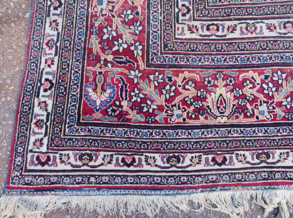 An antique hand-knotted Meshed Persian wool carpet featuring a central navy blue medallion on a distressed rose pink field surrounded by intricate floral borders. View VIII