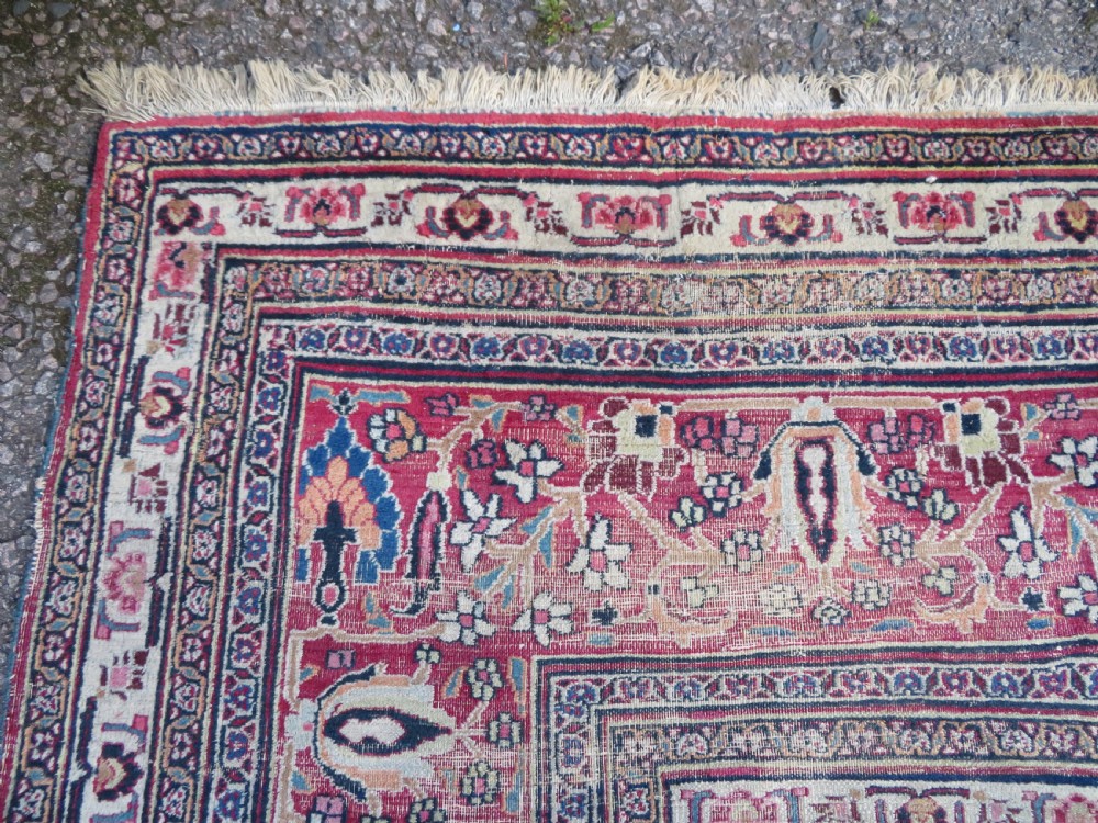 An antique hand-knotted Meshed Persian wool carpet featuring a central navy blue medallion on a distressed rose pink field surrounded by intricate floral borders. View X