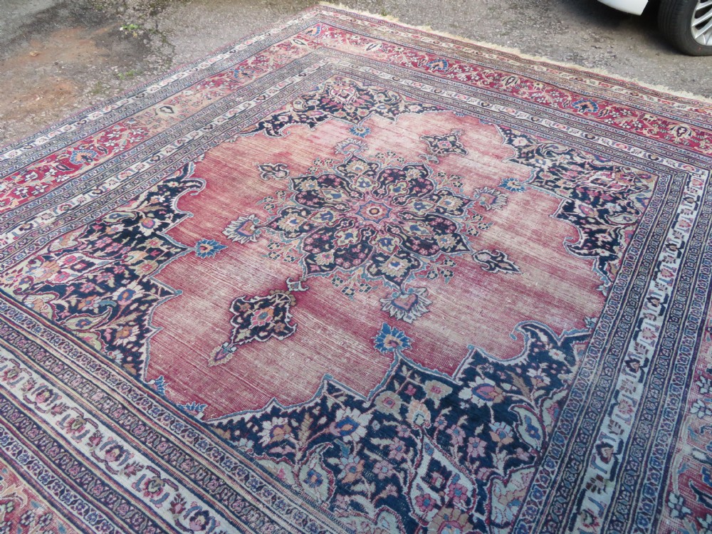An antique hand-knotted Meshed Persian wool carpet featuring a central navy blue medallion on a distressed rose pink field surrounded by intricate floral borders. View XIV