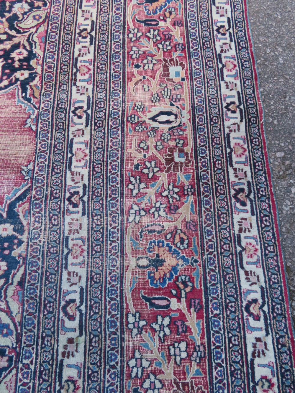 An antique hand-knotted Meshed Persian wool carpet featuring a central navy blue medallion on a distressed rose pink field surrounded by intricate floral borders. View XV