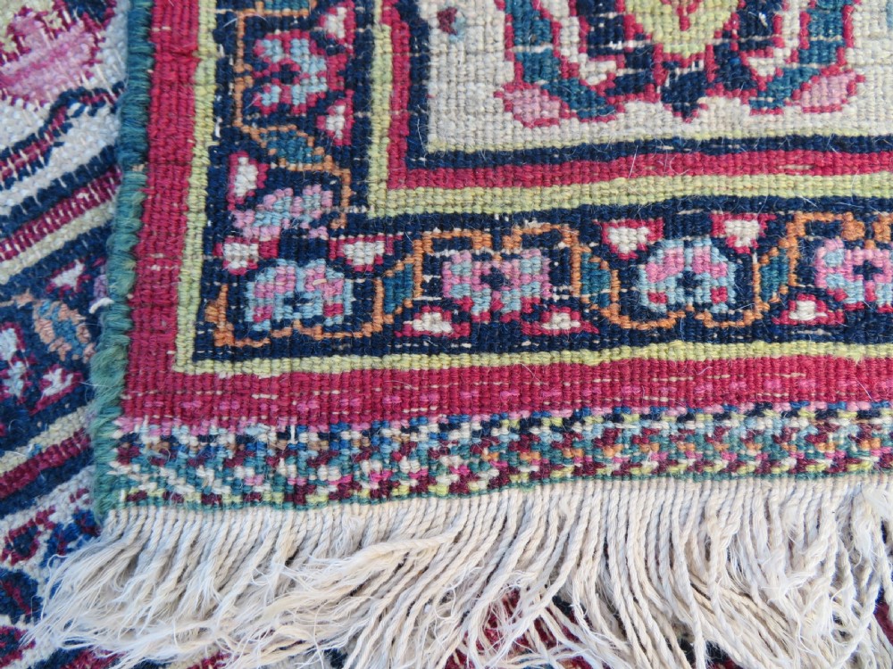An antique hand-knotted Meshed Persian wool carpet featuring a central navy blue medallion on a distressed rose pink field surrounded by intricate floral borders. View XVIII