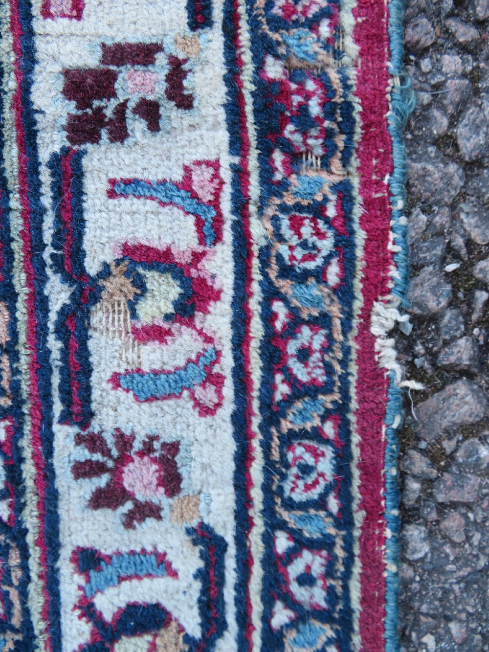 An antique hand-knotted Meshed Persian wool carpet featuring a central navy blue medallion on a distressed rose pink field surrounded by intricate floral borders. View XXI