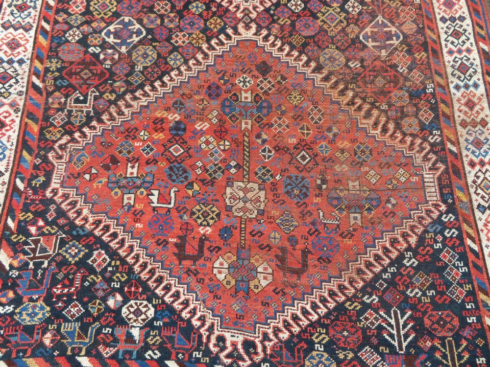 An antique Persian Luri hand-knotted wool carpet featuring three central diamond medallions surrounded by geometric tribal motifs and multi-banded borders. View III
