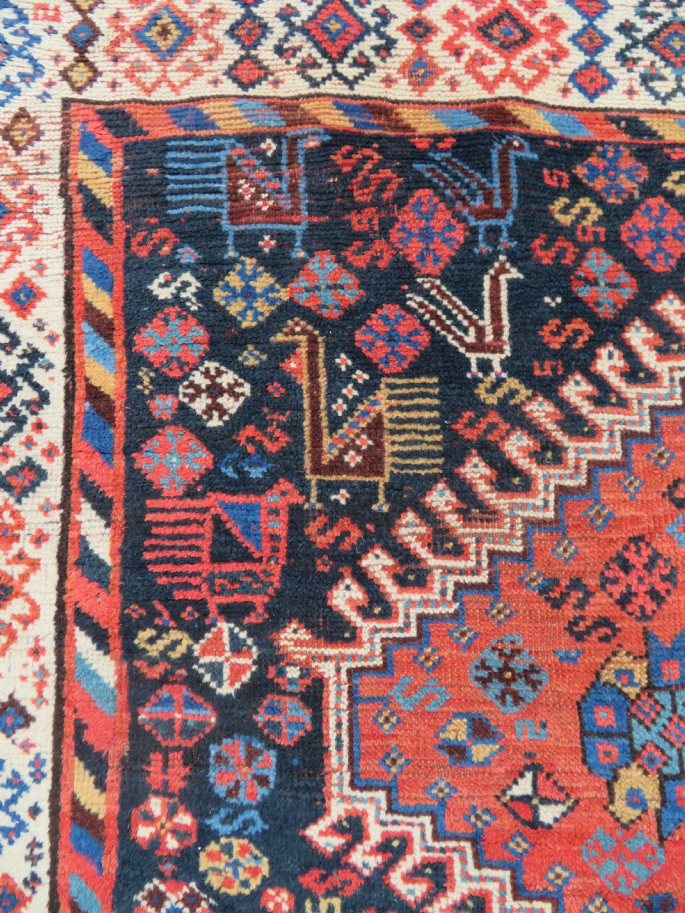 An antique Persian Luri hand-knotted wool carpet featuring three central diamond medallions surrounded by geometric tribal motifs and multi-banded borders. View VI