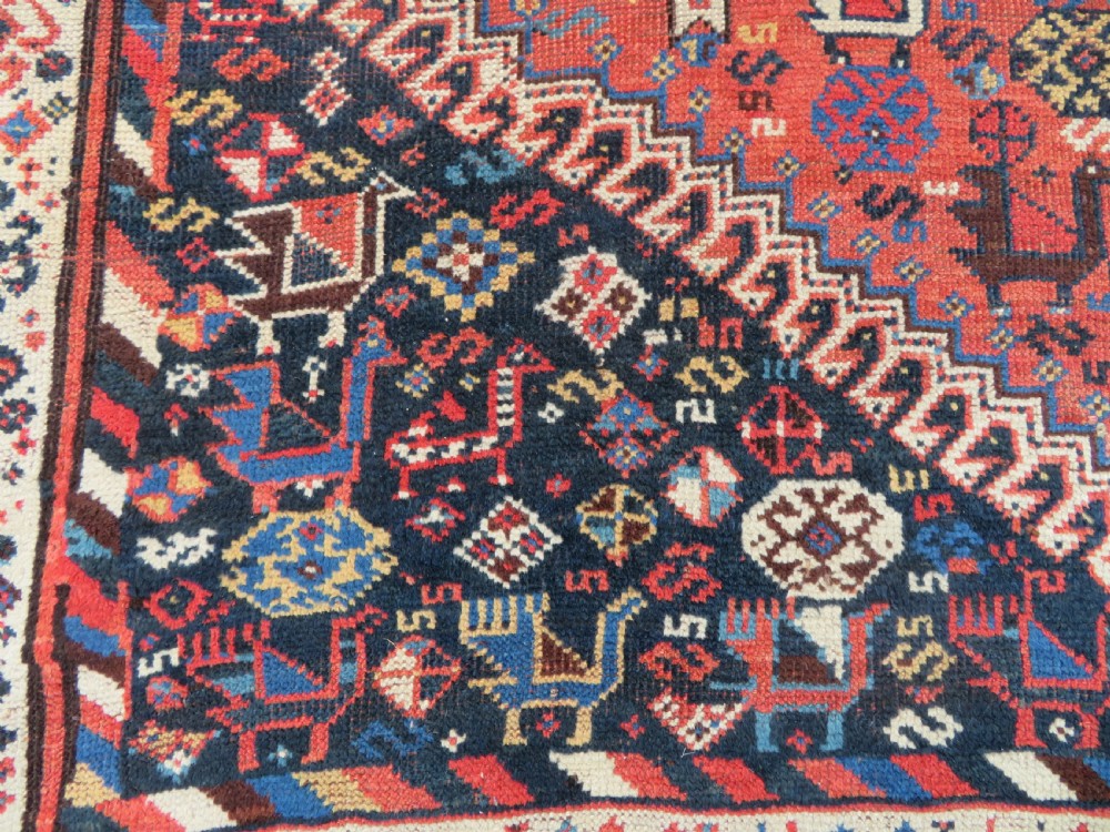 An antique Persian Luri hand-knotted wool carpet featuring three central diamond medallions surrounded by geometric tribal motifs and multi-banded borders. View IX