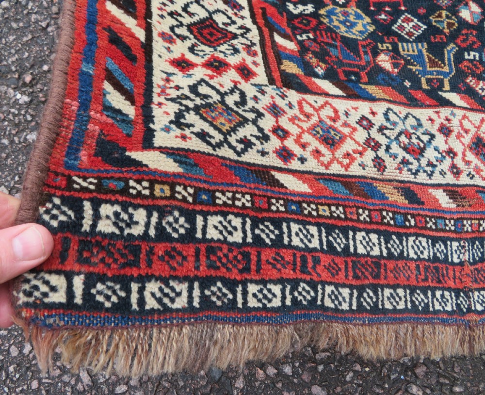 An antique Persian Luri hand-knotted wool carpet featuring three central diamond medallions surrounded by geometric tribal motifs and multi-banded borders. View XI