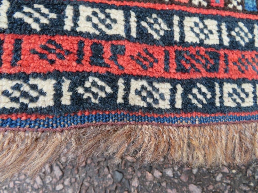 An antique Persian Luri hand-knotted wool carpet featuring three central diamond medallions surrounded by geometric tribal motifs and multi-banded borders. View XII