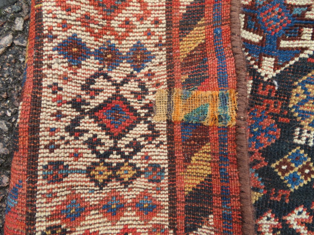 An antique Persian Luri hand-knotted wool carpet featuring three central diamond medallions surrounded by geometric tribal motifs and multi-banded borders. View XIV