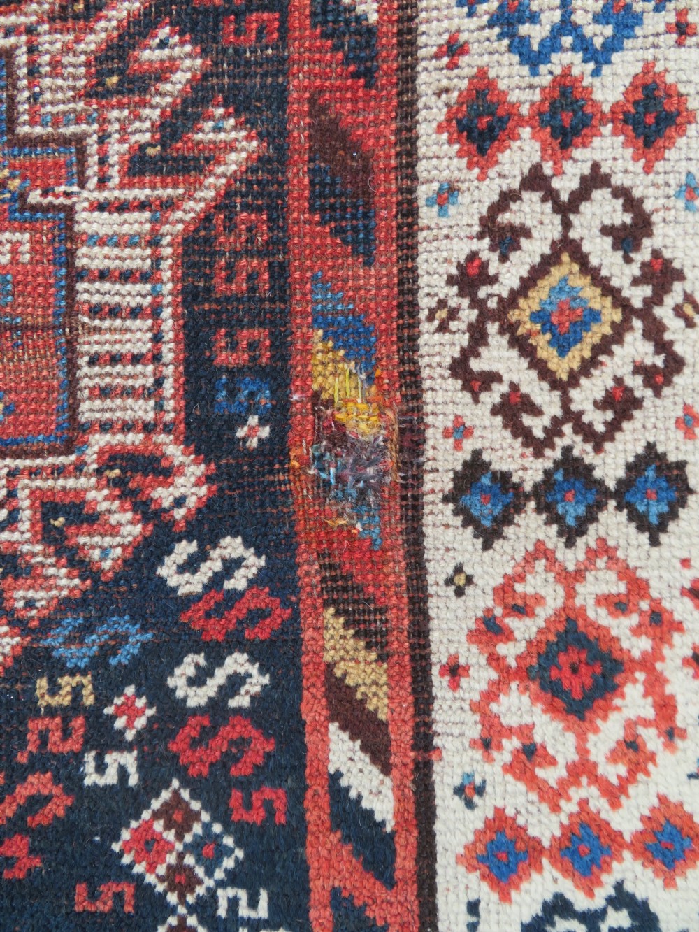 An antique Persian Luri hand-knotted wool carpet featuring three central diamond medallions surrounded by geometric tribal motifs and multi-banded borders. View XVI