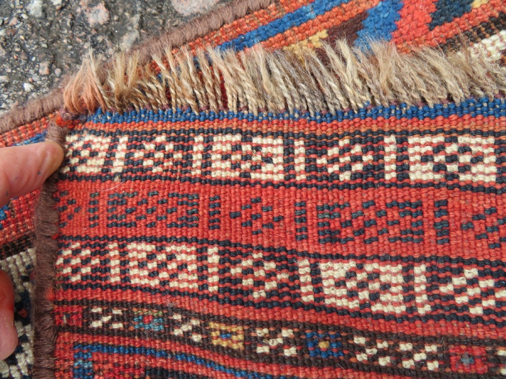 An antique Persian Luri hand-knotted wool carpet featuring three central diamond medallions surrounded by geometric tribal motifs and multi-banded borders. View XXI
