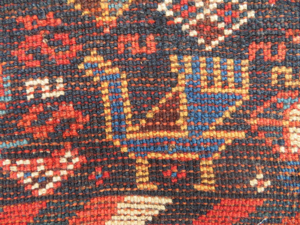 An antique Persian Luri hand-knotted wool carpet featuring three central diamond medallions surrounded by geometric tribal motifs and multi-banded borders. View XXII
