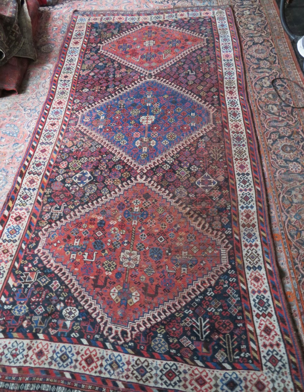 An antique Persian Luri hand-knotted wool carpet featuring three central diamond medallions surrounded by geometric tribal motifs and multi-banded borders. View XXIII