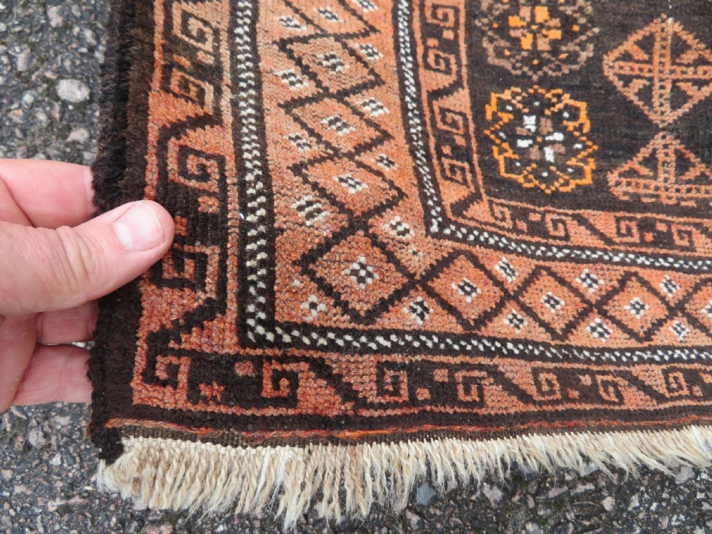 A hand-woven wool Afghan prayer rug featuring a dark brown central field with terracotta geometric motifs and a distinct pointed arch design. View III