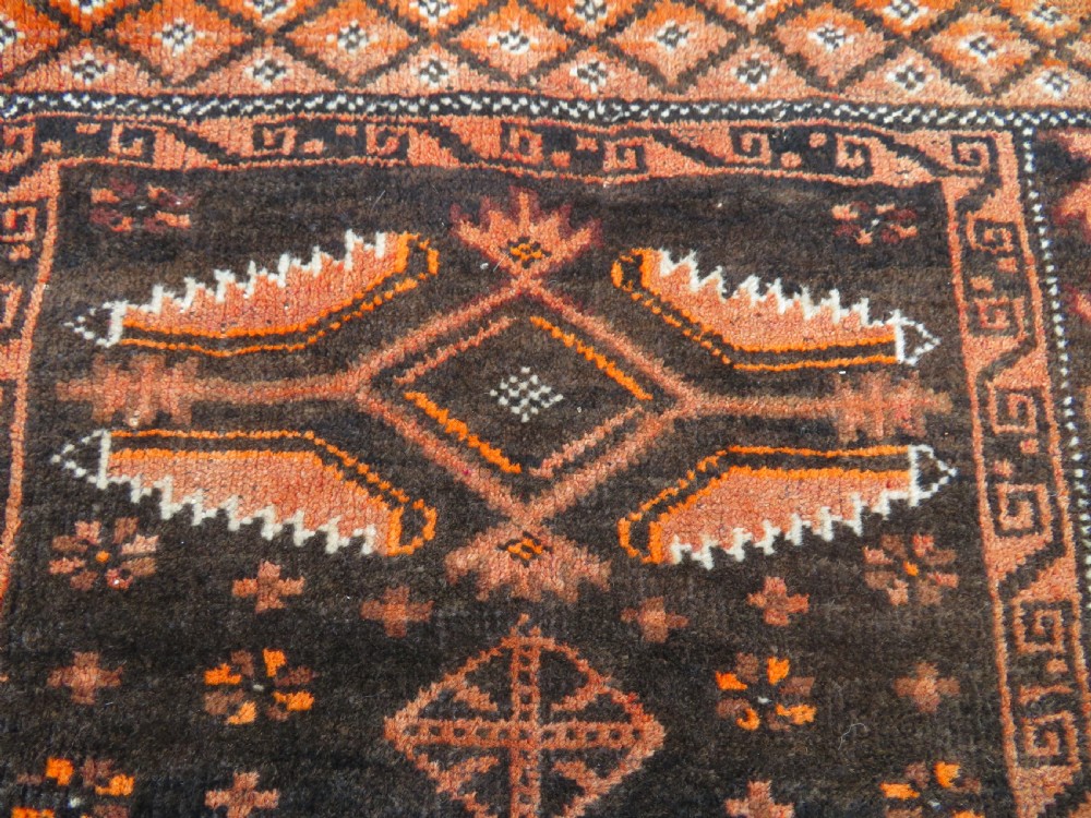 A hand-woven wool Afghan prayer rug featuring a dark brown central field with terracotta geometric motifs and a distinct pointed arch design. View IV