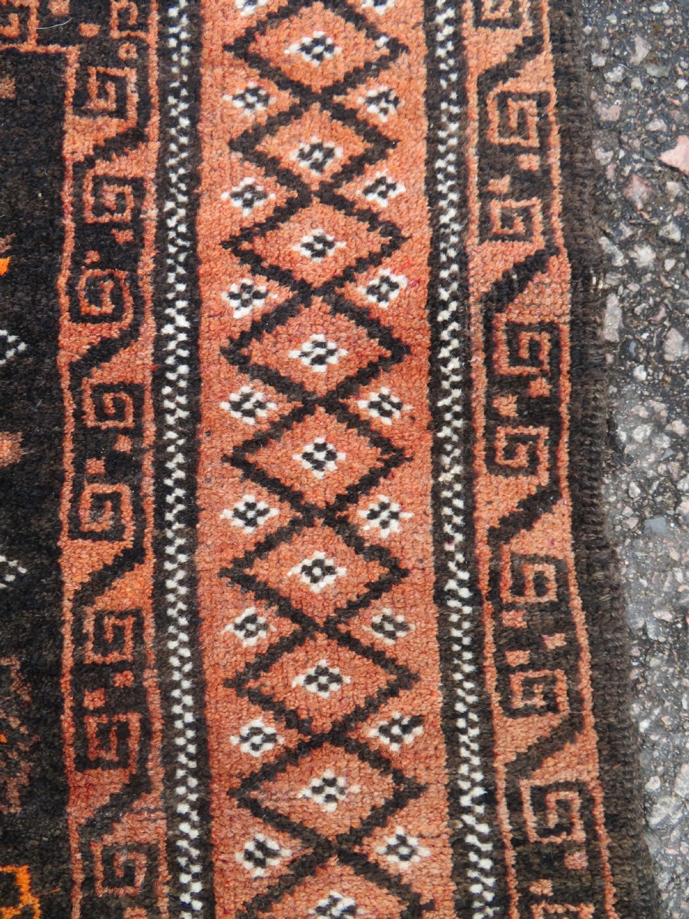 A hand-woven wool Afghan prayer rug featuring a dark brown central field with terracotta geometric motifs and a distinct pointed arch design. View V